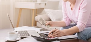 senior woman with calculator counting money